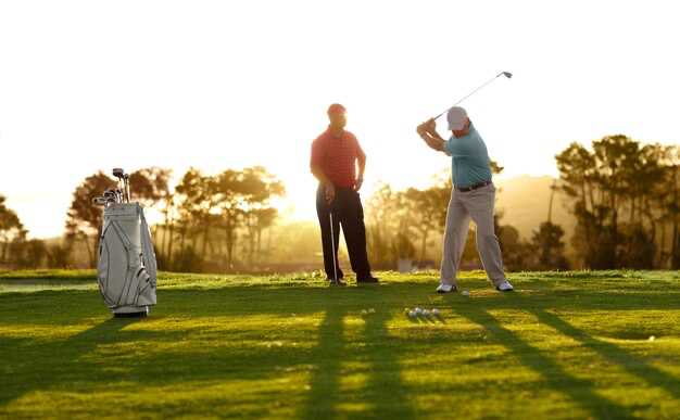 Two men playing golf in the morning on the course