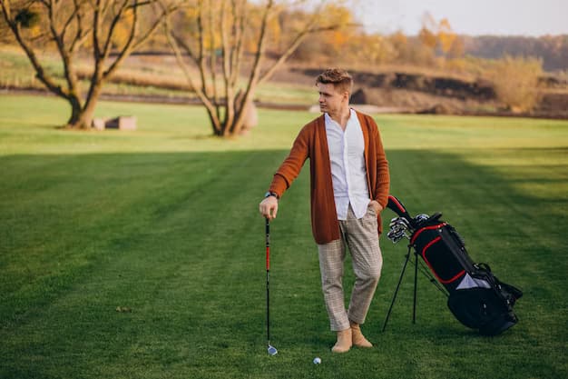 A man stands on a golf course next to a bag of clubs